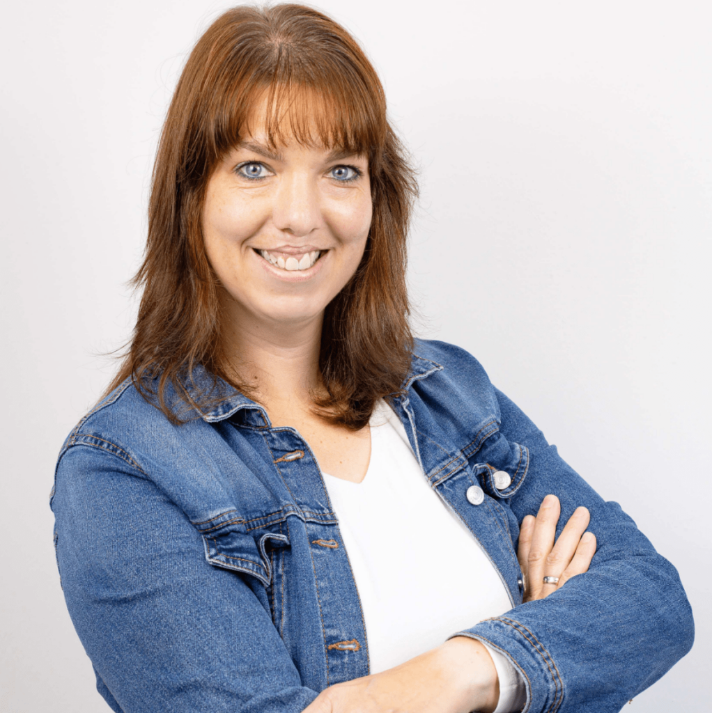 Kerstin Klingenberg: Porträtfoto einer jüngeren Frau mit schulterlangem, braunem Haar. Sie trägt eine Jeansjacke über einem weißen Oberteil, lächelt freundlich und hat die Arme vor der Brust verschränkt. Ihre Position ist in der Lohn- und Finanzbuchhaltung.